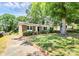 Charming brick home featuring a well-maintained lawn, mature trees, and a traditional design at 6517 Paleface Pl, Charlotte, NC 28214