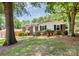Charming brick home with mature trees, lush greenery, and a inviting front porch at 6517 Paleface Pl, Charlotte, NC 28214