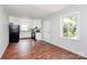 An open-concept kitchen featuring white cabinets, black appliances, and new wood flooring at 6517 Paleface Pl, Charlotte, NC 28214