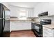 Traditional kitchen features white cabinets, dark appliances, and wood-look flooring at 6517 Paleface Pl, Charlotte, NC 28214