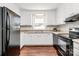Traditional kitchen features white cabinets, dark appliances, and wood-look flooring at 6517 Paleface Pl, Charlotte, NC 28214