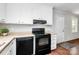 Kitchen features black appliances, white cabinetry, and sleek countertops, creating a clean, functional space at 6517 Paleface Pl, Charlotte, NC 28214