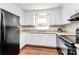 Traditional kitchen features white cabinets, dark appliances, and wood-look flooring at 6517 Paleface Pl, Charlotte, NC 28214