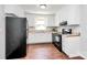 A bright kitchen featuring white cabinets, sleek black appliances, and new wood flooring at 6517 Paleface Pl, Charlotte, NC 28214
