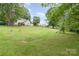 Large grassy backyard, perfect for outdoor activities and entertainment, with mature trees and play structure at 702 S Government St, Lincolnton, NC 28092
