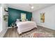 Bedroom featuring a decorative rug, wood floors, updated fixtures, natural light, and colorful accent wall at 702 S Government St, Lincolnton, NC 28092
