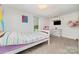 Bedroom with a bed, window, modern AC unit, TV, and minimalist decor, providing a comfortable living space at 702 S Government St, Lincolnton, NC 28092