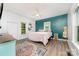Bedroom features decorative rug, wood floors, updated fixtures, natural light, and colorful accent wall at 702 S Government St, Lincolnton, NC 28092