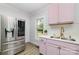 Renovated kitchen features stainless steel refrigerator and a basin sink with a modern faucet at 702 S Government St, Lincolnton, NC 28092