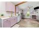 Modern kitchen features stainless steel appliances, pastel-colored cabinets, a large window, and wood-look floors at 702 S Government St, Lincolnton, NC 28092