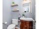 Charming half-bath with floating shelves, a stylish mirror, a toilet, and a petite vanity for guests' convenience at 812 Thornapple Ct, Lake Wylie, SC 29710