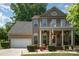 Charming two-story home featuring neutral exterior, a front porch balcony, and well-manicured landscaping at 812 Thornapple Ct, Lake Wylie, SC 29710