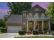 Charming two-story home with a welcoming porch, American flag, manicured landscaping, and a two-car garage at 812 Thornapple Ct, Lake Wylie, SC 29710
