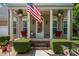 Charming front porch with decorative columns, an American flag, and inviting outdoor seating at 812 Thornapple Ct, Lake Wylie, SC 29710