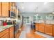 Well-lit kitchen with stainless steel appliances, hardwood floors, and barstool seating that seamlessly leads to the patio at 812 Thornapple Ct, Lake Wylie, SC 29710