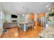 Open concept living and kitchen area with hardwood floors, kitchen island seating, and a cozy fireplace at 812 Thornapple Ct, Lake Wylie, SC 29710