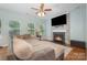 Cozy living room with a fireplace, neutral paint, a ceiling fan, and abundant natural light at 812 Thornapple Ct, Lake Wylie, SC 29710
