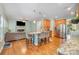 Open concept living and kitchen area with hardwood floors, kitchen island seating, and a cozy fireplace at 812 Thornapple Ct, Lake Wylie, SC 29710