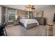 Spacious main bedroom with a fan, two windows, and neutral tones provide relaxation and comfort at 812 Thornapple Ct, Lake Wylie, SC 29710