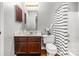 Bathroom with white tile, vanity with sink, mirror and a tub with a shower at 9021 Louvaine Dr, Charlotte, NC 28227