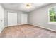 Spacious bedroom with double closets, carpeted floors, natural light, and a ceiling fan at 9021 Louvaine Dr, Charlotte, NC 28227