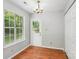 Bright dining area with wood floors, natural light from the window and updated lighting at 9021 Louvaine Dr, Charlotte, NC 28227