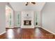 Bright living room featuring a vaulted ceiling, wood floors, and fireplace with brick surround at 9021 Louvaine Dr, Charlotte, NC 28227