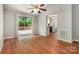 Open living room showing wood floors, a sliding glass door to the deck, and a view into the kitchen at 9021 Louvaine Dr, Charlotte, NC 28227