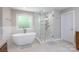 Bright bathroom featuring a free standing tub, glass enclosed shower, and wooden cabinets at 905 Patricians Ln, Monroe, NC 28110