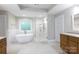 Bright bathroom featuring a free standing tub, glass enclosed shower, and wooden cabinets at 905 Patricians Ln, Monroe, NC 28110