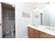 Bathroom featuring double sink vanity with wood cabinets, a large mirror, and adjacent toilet room at 905 Patricians Ln, Monroe, NC 28110