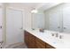 Bathroom features a double sink vanity with brown cabinets and a large mirror at 905 Patricians Ln, Monroe, NC 28110