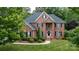 Brick home with mature landscaping, manicured lawn, and black shutters at 905 Patricians Ln, Monroe, NC 28110
