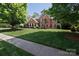 Beautiful two-story brick home with a well-maintained lawn and mature trees at 905 Patricians Ln, Monroe, NC 28110
