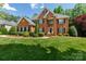 Stately brick home featuring manicured lawn, mature trees, and classic architectural details at 905 Patricians Ln, Monroe, NC 28110