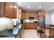 Functional kitchen featuring wood cabinets, stainless steel appliances, dark counters and an island with seating at 905 Patricians Ln, Monroe, NC 28110