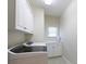 Bright laundry room with white cabinets and modern washing machine at 905 Patricians Ln, Monroe, NC 28110