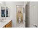Bright bathroom with a white vanity, mirror, and view into another bathroom, designed for functionality at 909 Staghorn Ln, Waxhaw, NC 28173