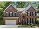 Beautiful two-story brick home with attached two-car garage and mature landscaping at 909 Staghorn Ln, Waxhaw, NC 28173