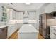 Well-lit kitchen features white cabinets, stainless steel appliances, and a large island at 909 Staghorn Ln, Waxhaw, NC 28173