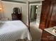 Spacious main bedroom features four poster bed, carpet, and ensuite bath at 909 Staghorn Ln, Waxhaw, NC 28173