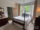 Bright bedroom with bay window, four-poster bed, and view into ensuite bathroom at 909 Staghorn Ln, Waxhaw, NC 28173