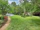 Expansive backyard with lush greenery and a brick walkway leading to outdoor features at 104 Tobe Bridge Rd, Kings Mountain, NC 28086