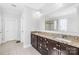 Double vanity bathroom with dark cabinets, granite countertops, tiled floors, and large mirror reflects luxury and convenience at 10693 Sky Chase Nw Ave, Concord, NC 28027