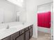 Bright bathroom features double sink vanity, large mirror, and shower with a red curtain at 10693 Sky Chase Nw Ave, Concord, NC 28027