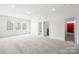 A large bonus room with plush carpeting and natural light flowing through the windows, creating a relaxing atmosphere at 10693 Sky Chase Nw Ave, Concord, NC 28027