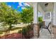 Inviting front porch with brick detailing, iron railings, and comfortable seating area amid lush landscaping at 10693 Sky Chase Nw Ave, Concord, NC 28027