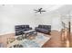 Bright living room featuring hardwood floors, modern ceiling fan, and comfortable leather seating at 10693 Sky Chase Nw Ave, Concord, NC 28027