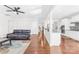 Open-concept layout with hardwood floors seamlessly connecting living room to kitchen with white cabinetry at 10693 Sky Chase Nw Ave, Concord, NC 28027