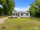 Charming single-story home with manicured lawn, mature trees, and a freshly painted white exterior at 109 Jackson St, Salisbury, NC 28144